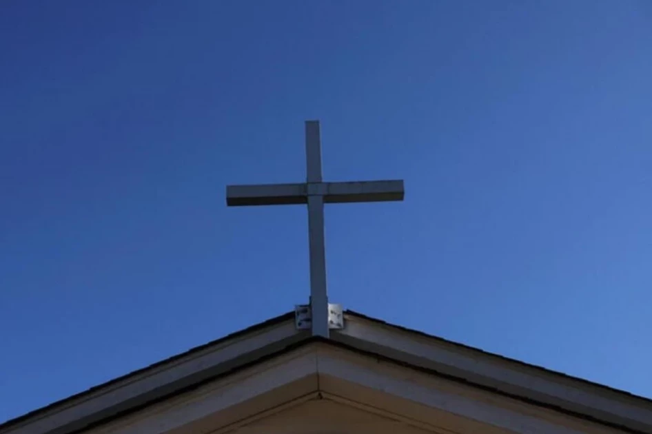 A cross is seen on the roof of a church. REUTERS/FILE